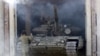 A member of the self-proclaimed Luhansk People's Republic (LNR) forces guides a tank to park after withdrawing it further from the frontline outside Luhansk, Ukraine, Oct. 3, 2015.