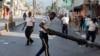 A national police officer removes a barricade in the street during a protest to demand the resignation of President Jovenel Moise, in Port-au-Prince, Haiti, Nov. 10, 2019. 