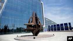 The NATO symbol in front of the glass facade of the new NATO headquarters in Brussels on Thursday, April 19, 2018.