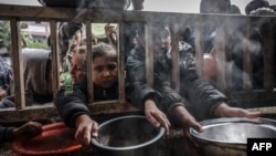 Raseljena palestinska djeca u redu za pomoć u Rafi (Foto: MOHAMMED ABED / AFP)