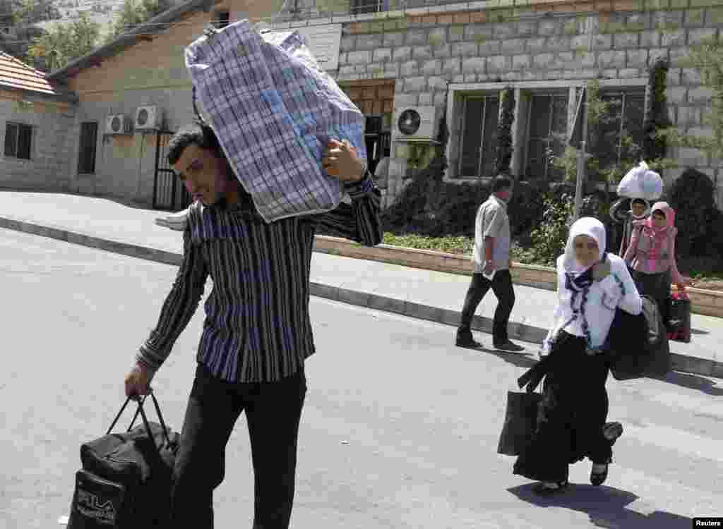 Suriyalik qochqinlar Livan-Suriya chegarasidan o'tmoqda, 20-iyul, 2012-yil.