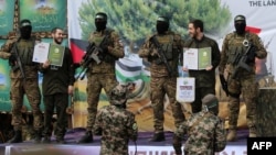 Les otages israéliens Eliya Cohen et Omer Shem Tov exhibés par le Hamas à Nuseirat dans la bande de Gaza, après leur libération dans le cadre d'un échange avec Israël le 22 février 2025. (Photo AFP)
