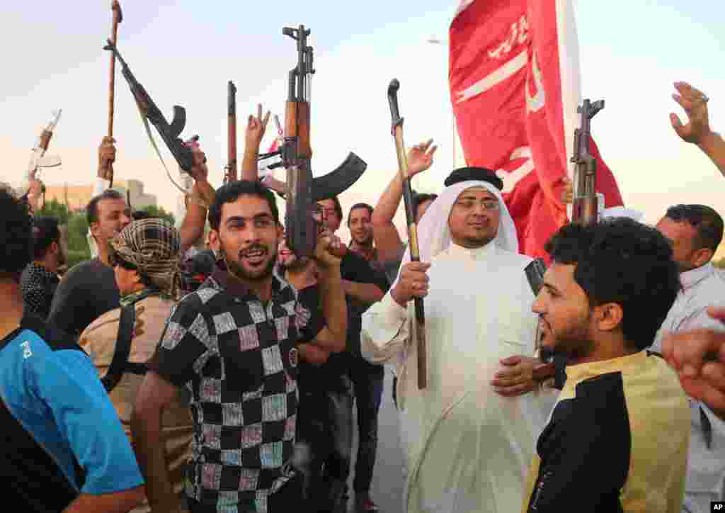 Basra shahridagi Shia jangarilari "Iroq va Shom islomiy davlati" guruhiga qarshi qo'lida qurol bilan, 15-iyun, 2014-yil.