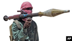 FILE - An al-Shabab fighter displays a weapon during exercises at training camp outside Mogadishu, Somalia.