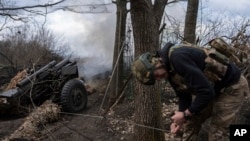 A Ukrainian serviceman of the Khartia brigade fires an M101 Howitzer toward Russian positions in Ukraine's Kharkiv region, March 12, 2025.
