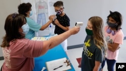 រូបឯកសារ៖ គ្រូៗ ពិនិត្យ​មើល​កំដៅខ្លួន​របស់​សិស្ស​មុន​អនុញ្ញាត​ឲ្យ​ចូល​ជំរំ​រដូវ​ក្តៅ STEM នៅ​វិទ្យាល័យ Wylie ក្នុង​ទីក្រុង Wylie រដ្ឋតិចសាស កាលពី​ថ្ងៃទី១៤ ខែកក្កដា ឆ្នាំ២០២០។