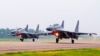 FILE - Two Chinese SU-30 fighter jets take off from an unspecified location to fly a patrol over the South China Sea, in this undated file photo released by China's Xinhua News Agency.
