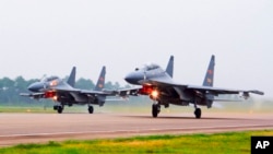 FILE - Two Chinese SU-30 fighter jets take off from an unspecified location to fly a patrol over the South China Sea, in this undated file photo released by China's Xinhua News Agency.