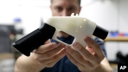Cody Wilson holds a 3D-printed gun at his shop in Austin, Texas, Aug. 1, 2018.