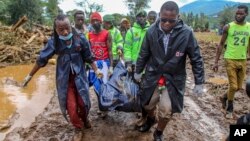 FILE - Kenya Red Cross workers and volunteers, carry a man's body retrieved from mud, after floodwater washed away houses, in Kamuchiri Village Mai Mahiu, Nakuru County, Kenya, Tuesday, April 30, 2024. (AP Photo/Patrick Ngugi, File)
