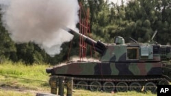 FILE - In this Taiwan Military News Agency photo, a Taiwan artillery gun fires a live round during exercises in Taichung, Taiwan, Sept. 16, 2021. U.S. defense officials are refusing to confirm reports that American forces are in Taiwan, secretly training Taiwanese troops.
