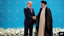 Президент Росії Володимир Путін і президент Ірану Ебрагім Раісі потискають один одному руки перед переговорами в палаці Саадабад, Тегеран, Іран, 19 липня 2022 р. Sergei Savostyanov, Sputnik, Kremlin Pool Photo via AP