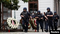Police officers walk at the site of wreath laying ceremony after exchanges of gunfire in Vienna, Austria, Nov. 3, 2020. 