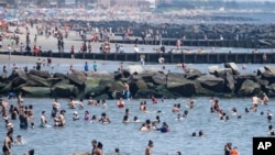 Revelers enjoy the beach at Coney Island, Saturday, July 4, 2020, in the Brooklyn borough of New York. (AP Photo/John Minchillo)