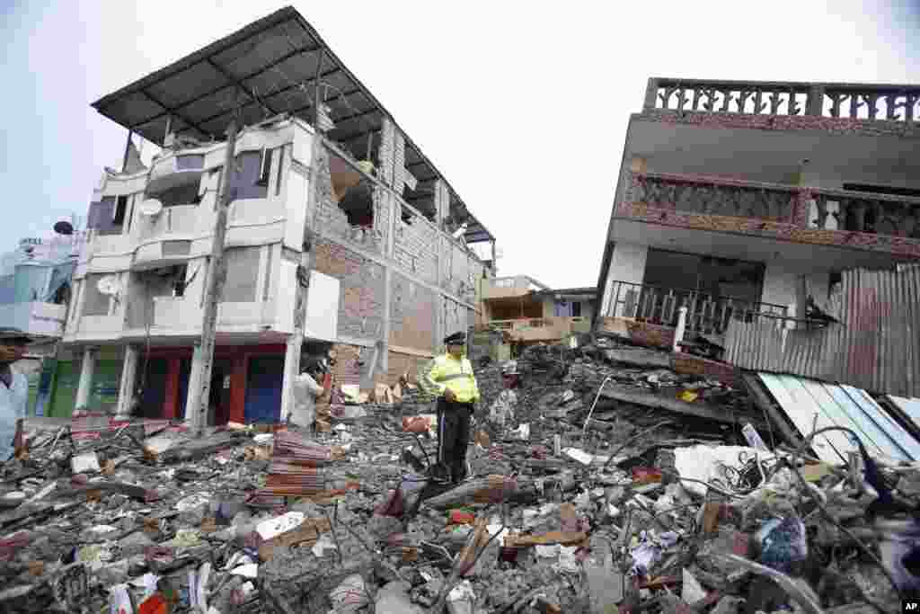 A police officer stands on debris, next to buildings destroyed by an earthquake in Pedernales, Ecuador, April 17, 2016.&nbsp;The earthquake flattened buildings and buckled highways along its Pacific coast, sending the Andean nation into a state of emergency.