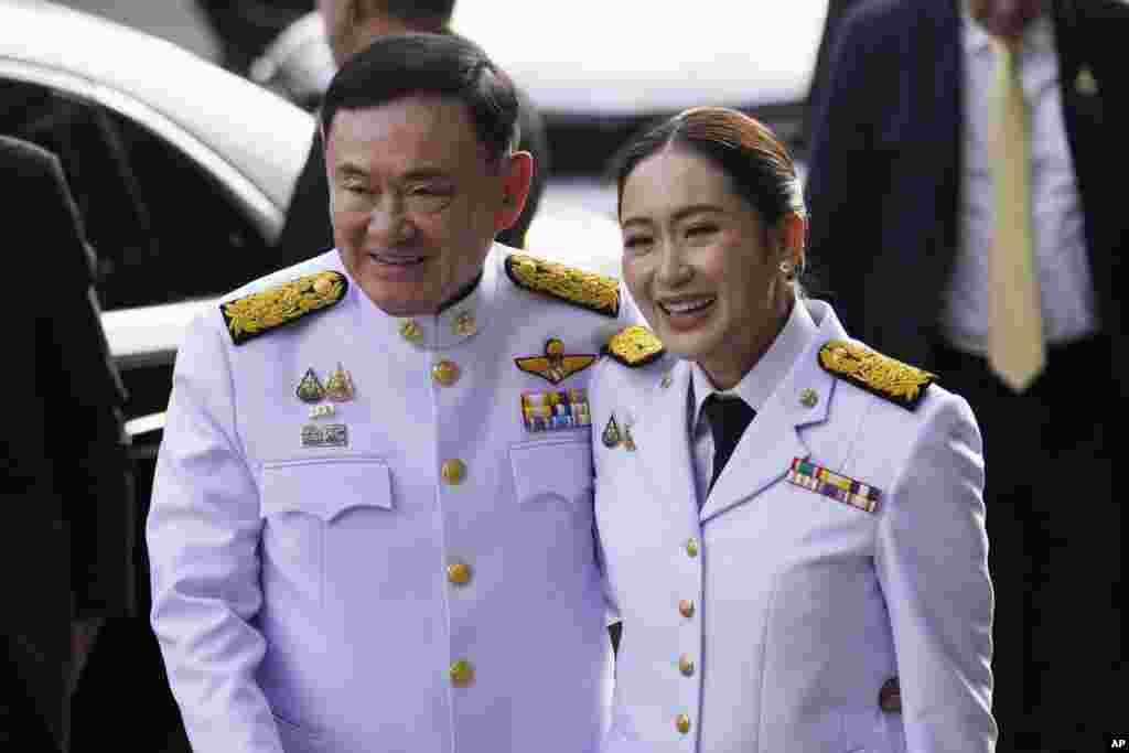 Thailand's former Prime Minister Thaksin Shinawatra, left, and his daughter and newly elected Prime Minister Paetongtarn Shinawatra arrive before the royal endorsement ceremony appointing Paetongtarn as Thailand's new prime minister at Pheu Thai party headquarters in Bangkok