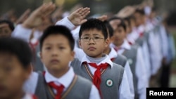 Young Pioneers salute during the weekly flag-raising ceremony at the East Experimental School in Shanghai November 5, 2012. Created in 1949, the Young Pioneers movement is considered a seedbed for future members of the Chinese Communist Party, and consist