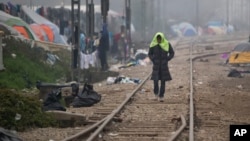A migrant man walks on railway tracks with a towel on his head at the northern Greek border point of Idomeni, Greece, March 18, 2016.