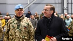 Міністр оборони Німеччини Борис Пісторіус із полковником Гайко Бонсаком, зустрічають останній контингент солдат німецької армії Бундесверу, який повертається з миротворчої місії MINUSMA в Малі. Вунсторф, Німеччина, 15-го грудня 2023 року. REUTERS/ Лізі Ніснер