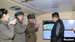 North Korean leader Kim Jong Un speaks with officials during an observation of what state media report is a hypersonic missile test at an undisclosed location in North Korea, January 11, 2022, in this photo released January 12, 2022 by North Korea's Korean Central News Agency.