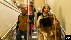 Supporters of President Donald Trump walk down the stairs outside the Senate Chamber as violence erupted at the Capitol following a breach of security, Jan. 6, 2021, in Washington.