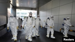 Workers from a disinfection service company sanitize a branch of the Shincheonji Church of Jesus the Temple of the Tabernacle of the Testimony where a woman known as "Patient 31" attended a service in Daegu, South Korea, February 19, 2020.