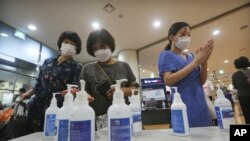 Christians wearing face masks to help protect against the spread of the new coronavirus use hand sanitizer before attending a service at the Yoido Full Gospel Church in Seoul, South Korea, Sunday, July 5, 2020. (AP Photo/Ahn Young-joon)