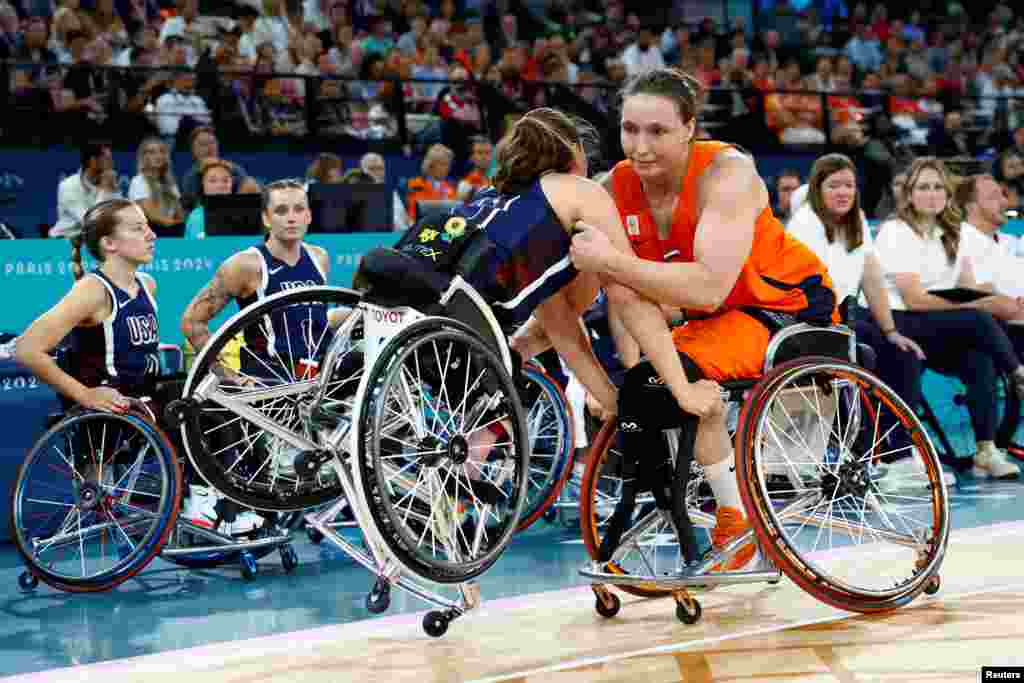 Mariska Beijer of Netherlands stops Kaitlyn Eaton of United States from falling during the women's wheelchair basketball gold medal match between Netherlands and United States in Paris 2024 Paralympics.