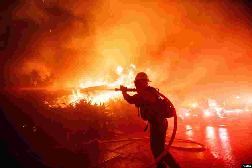 A firefighter battles the Palisades Fire as it burns during a windstorm on the west side of Los Angeles, California, Jan. 7, 2025.
