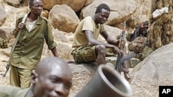 SPLA-N fighters practice with a mortar as others watch near Jebel Kwo village in the rebel-held territory of the Nuba Mountains in South Kordofan, Sudan May 2, 2012.