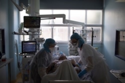 Health care workers assist a COVID-19 patient in the intensive care unit at the Joseph Imbert Hospital Center in Arles, southern France, April 5, 2020.