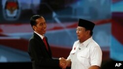 Indonesia's presidential candidate Joko "Jokowi" Widodo (L) shakes hands with his opponent Prabowo Subianto after a debate in Jakarta June 15, 2014.