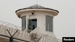 FILE - A guard stands in a watchtower in Kashgar, Xinjiang Uyghur Autonomous Region, China, May 3, 2021. 