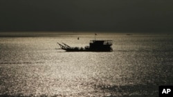 FILE - A ferry transports people from Phnom Penh to Arey Ksat across the Mekong River outside Phnom Penh, Cambodia, Jan. 28, 2020.