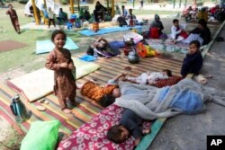 FILE - Afghan children sleep in an area where displaced people have put up makeshift tents while they seek asylum from the U.N. High Commissioner for Refugees outside the Islamabad Press Club in Islamabad, Pakistan, May 9, 2022.