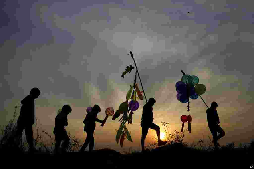 Indian balloon vendors walk back home as the sun sets on New Year's Eve in Jammu, India.