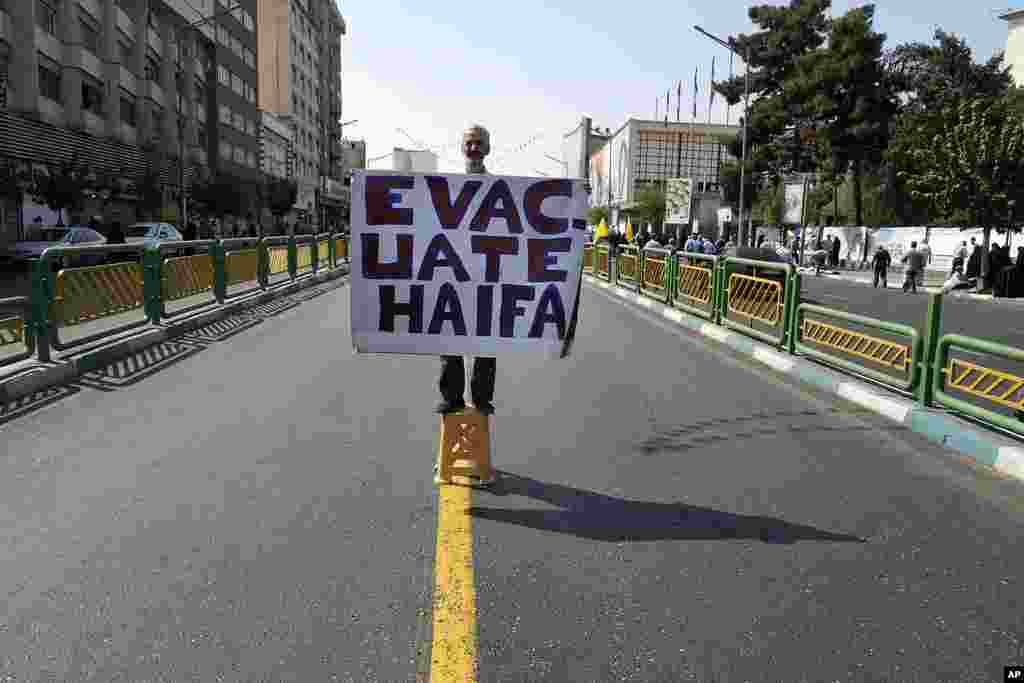 A man holds an anti-Israel placard calling for the evacuation of the northern Israeli city of Haifa, during a rally to support Lebanon's militant Hezbollah group and Palestinians after Friday prayers in Tehran, Iran.