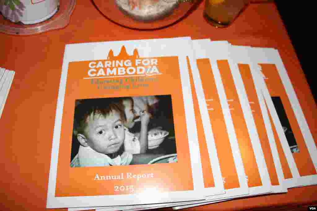 Annual reports of Caring for Cambodia are displayed at a Washington, DC fundraiser and silent auction organized by the non-profit to help support 21 impoverished schools in Cambodia's Siem Reap province, May 4, 2017. (VOA Khmer)