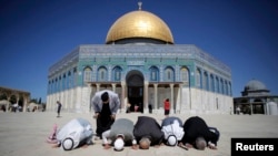 Palestinians pray in front of the Dome of the Rock at the compound known to Muslims as Noble Sanctuary and to Jews as Temple Mount in Jerusalem's Old City, Oct. 5, 2014.