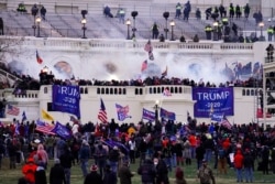 FILE - Protesters loyal to then-President Donald Trump storm the Capitol, Jan. 6, 2021. A DEA agent was arrested on charges stemming from the riot.