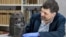 Neil Curtis, head of Museums and Special Collections is seen with one of the Benin bronze depicting the Oba of Benin at The Sir Duncan Rice Library, the University of Aberdeen, Scotland, March 17, 2021. (University of Aberdeen/Handout via Reuters)