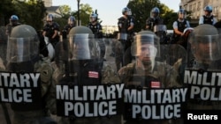 FILE - DC National Guard Military Police officers and law enforcement officers stand guard during a protests against the death in Minneapolis custody of George Floyd, near the White House in Washington, June 1, 2020. 