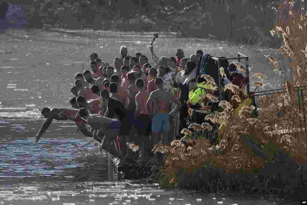 Патріарх Болгарії Данаїл кидає дерев'яний хрест у озеро, а віряни стрибають у воду, щоб його повернути. Софія, Болгарія, 6 січня 2025 року (AP Photo/Valentina Petrova)