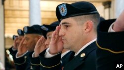 Army recruiters salute during the playing of the national anthem at the change of command ceremony for the Jackson, Miss., March 12, 2014. (AP Photo/Rogelio V. Solis)