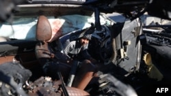 A man checks a car hit by an Israeli strike in Khan Yunis, Gaza Strip, on Nov. 30, 2024, in which five people were killed, including three World Central Kitchen aid workers.