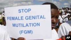 Msichana wa kimasai ameshika bango akipinga ukeketaji wanawake (FGM) nchini Kenya.
