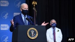 El presidente de EEUU, Joe Biden, habla, flanqueado por el asesor médico jefe de la Casa Blanca sobre Covid-19, el Dr. Anthony Fauci (derecha), durante una visita a los Institutos Nacionales de Salud (NIH) en Bethesda, Maryland, el 11 de febrero de 2021. (Foto de SAUL LOEB / AFP)