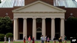 FILE - A group walks across the lawn on the campus of Wake Forest University in Winston-Salem, N.C., May 28, 2014. 