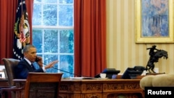 FILE - President Barack Obama is photographed through the window as he speaks in the Oval Office during a conference call at the White House in Washington, June 2, 2014.
