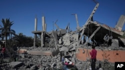 Palestinezët inspektojnë rrënojat e një ndërtese të shkatërruar nga një sulm izraelit në Rripin e Gazës, më 4 dhjetor, 2024/AP